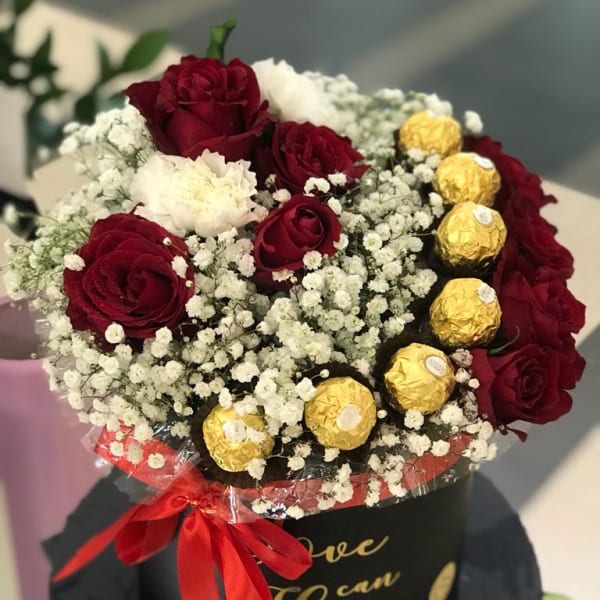 In a black box, red roses and white carnations with gypsophila filling and Ferrero Rocher toppings. 