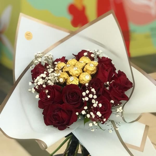 A bouquet of red roses with baby's breath filling stuffed with Ferrero Rocher topping. 