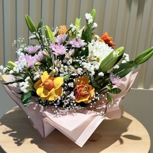Aria Blossom Symphony bouquet showcasing vibrant orange roses and white lilies