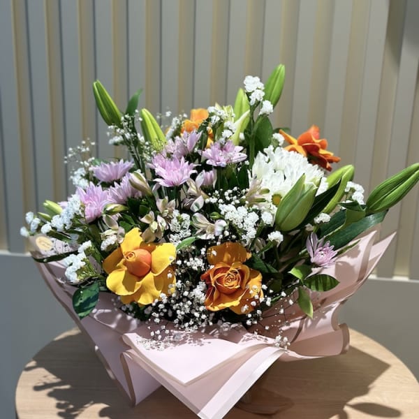 Beautifully wrapped Aria Blossom Symphony bouquet with delicate Gypsophila accents