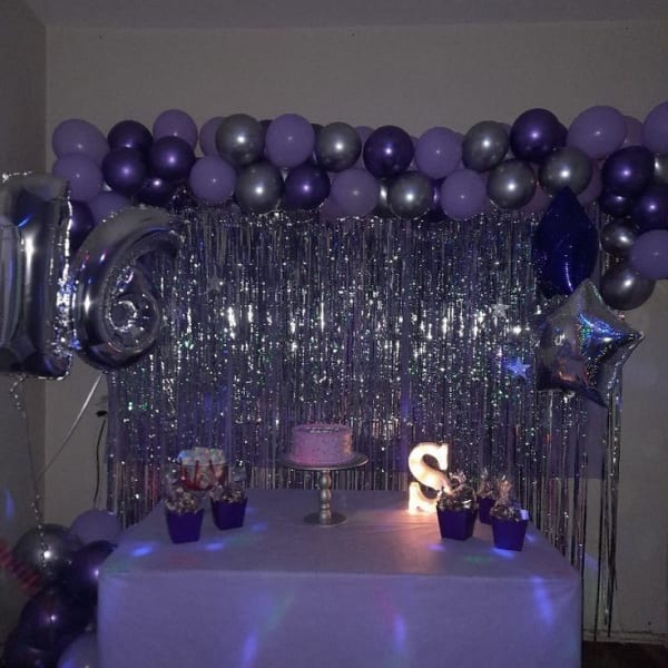 Vibrant purplish-themed balloons, elegant number balloons, delicious cake, and meaningful cactus decor at a celebration.