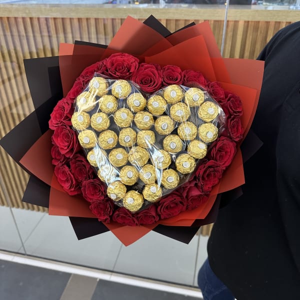 Exquisite bouquet featuring red roses and delectable Ferrero Rocher chocolates.