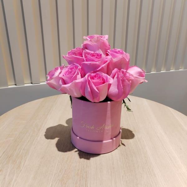 Close-up of 13 pink roses in a pink velvet box