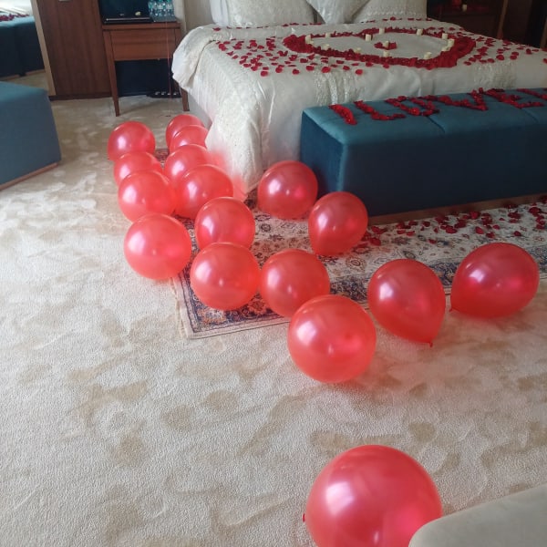 Red balloons in line with bed