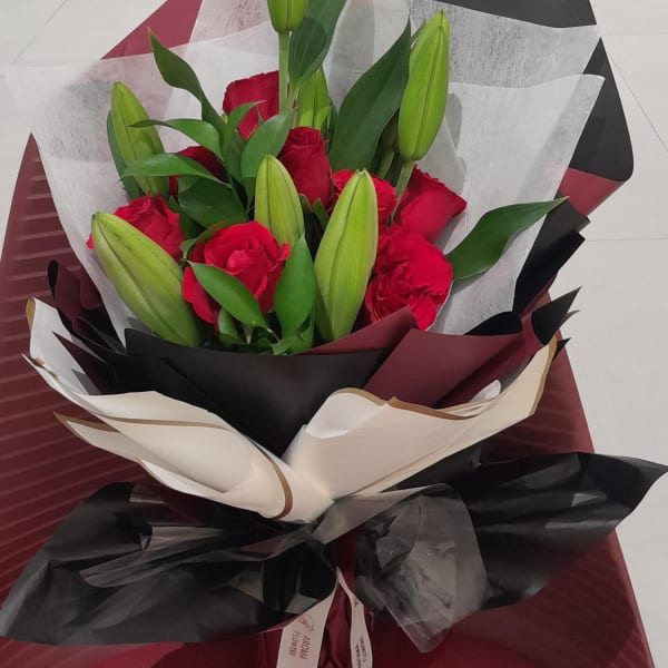 Bouquet of red roses and a white lily