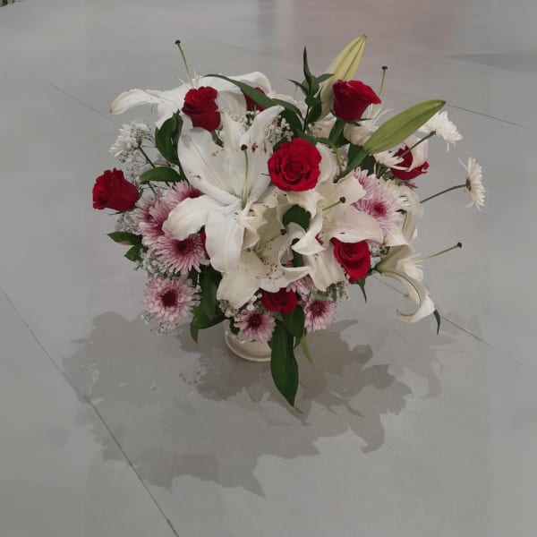 A crystal vase packed with floral superpowers - red roses for passion, white gypsophila for purity, and more!

