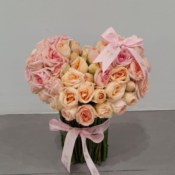 A beautiful floral arrangement in the shape of a heart, conveying love and affection.