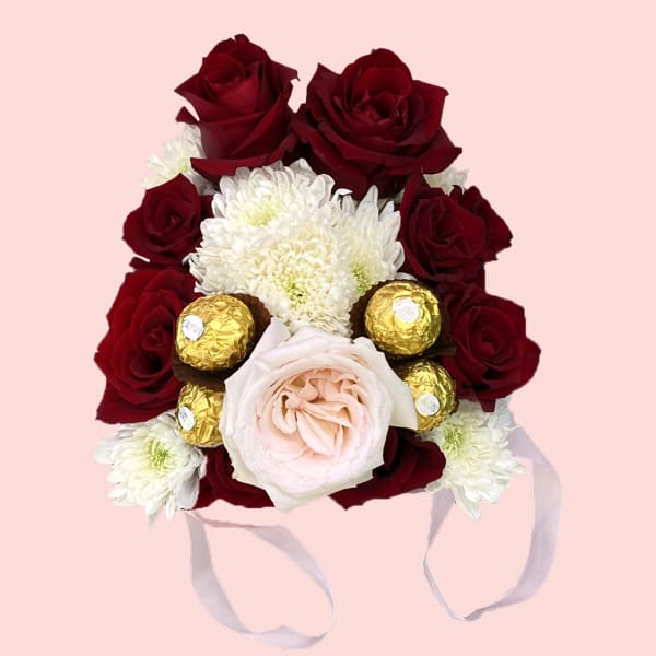  Red roses with an elegant big Pink rose and a filling of chrysanthemum and Ferrero Rocher chocolate balls in a Pink Bucket.