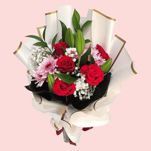 A bouquet of fiery red roses, delicate white lilies, cheerful purple chrysanthemums, and wispy Gypsophila.