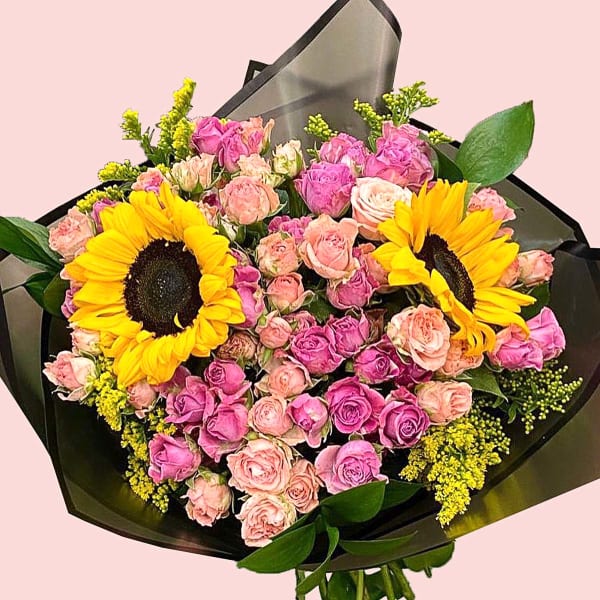 Bouquet of Sunflowers, dark light pink roses, solidago and eucalyptus in black wrapping. 