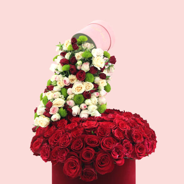 Luxurious red rose arrangement in a red velvet hatbox.