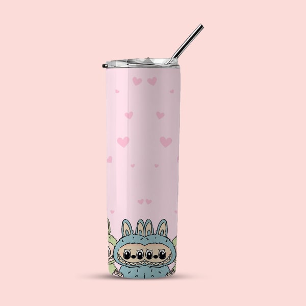 A pink tumbler with small pink hearts and a blue monster in a bunny suit at the bottom, shown with a lid and straw against a light pink background.
