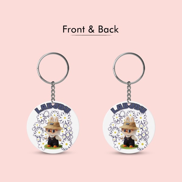 A close-up shot of a white circular keychain featuring the character Labubu wearing a straw hat and surrounded by daisies. The image also shows the keychain's diameter, which is 6.5 cm.