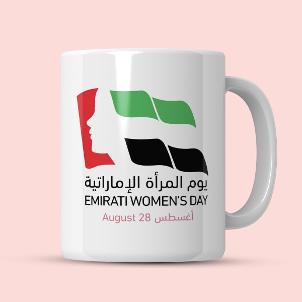 A ceramic mug with a print celebrating Emirati Women's Day, showing a woman's profile and the UAE flag, with dimensions (9.6 cm height, 8 cm diameter) indicated by dotted lines.