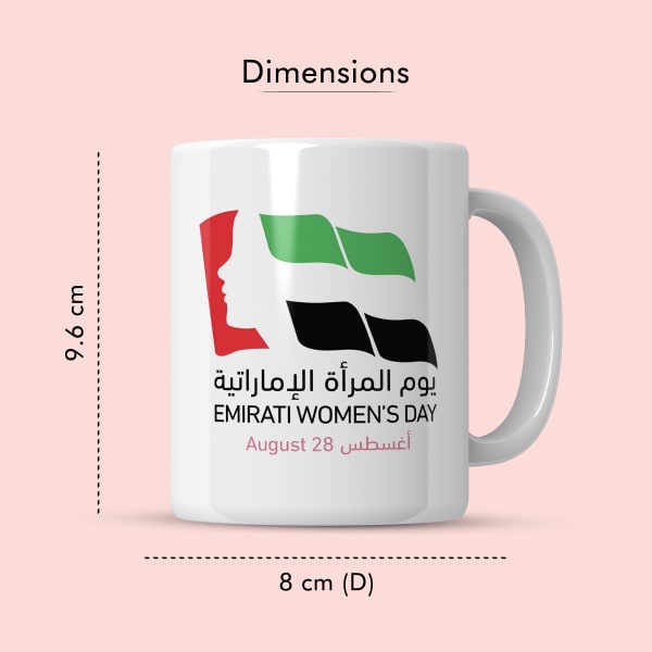 A ceramic mug with a print for Emirati Women's Day, featuring a woman's profile silhouette and the UAE flag, displayed against a light pink background.