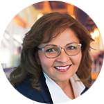 professional woman with glasses smiling confidently in a modern workspace, business portrait with soft background lighting