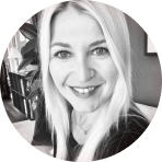 smiling woman with long blonde hair in a circular frame, cozy indoor setting with books in the background, professional portrait in black and white