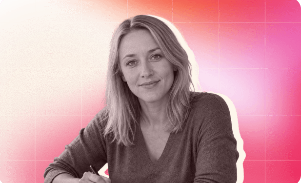 smiling woman with long blonde hair in a gray sweater, seated with a pen, against a vibrant pink gradient background, professional portrait with colorful backdrop