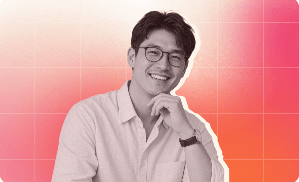 smiling man in glasses with a hand on his chin, wearing a light shirt against a gradient orange background, portrait of a confident young professional