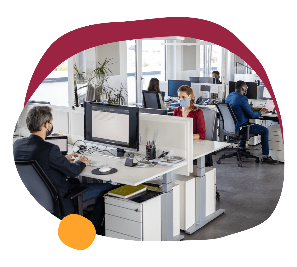 office workspace with employees in masks, modern desk arrangements and technology in a bright environment