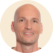 bald man smiling, close-up portrait with neutral background