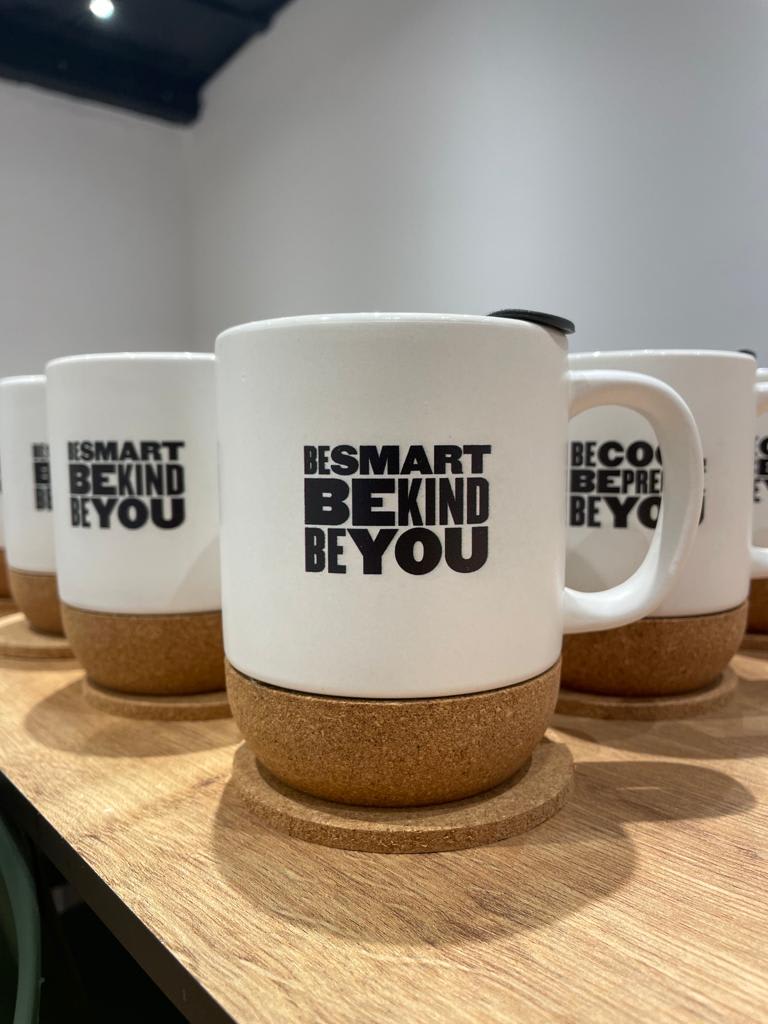 mugs with motivational quotes on a wooden surface, featuring a cork base for insulation, crafted ceramic mugs promoting positivity