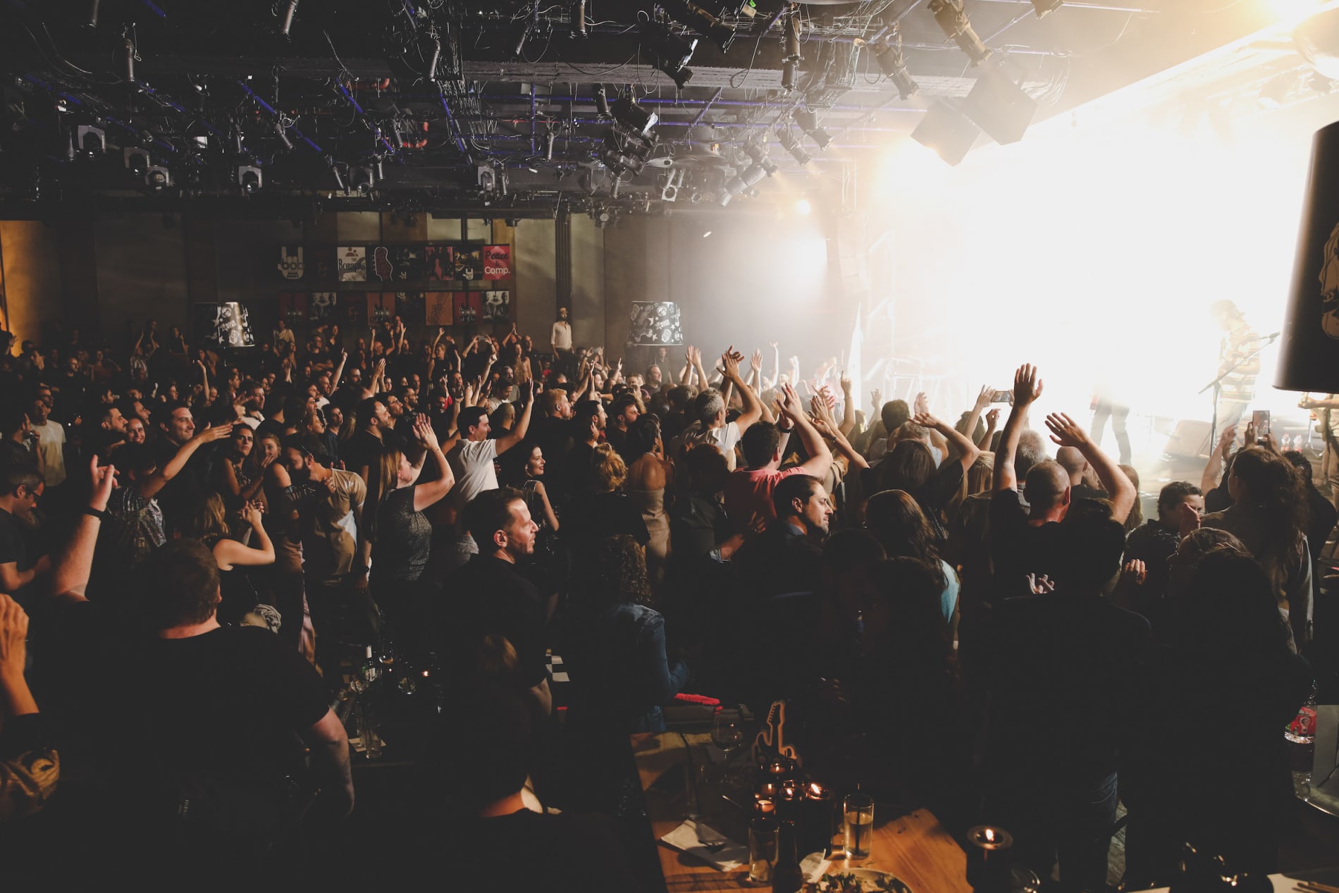 crowd enjoying a live concert with raised hands and a vibrant atmosphere, concert audience celebrating music energy and excitement