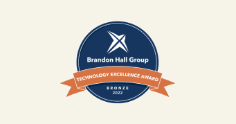 Brandon Hall Group Technology Excellence Award bronze seal 2022, round badge with navy background and orange ribbon