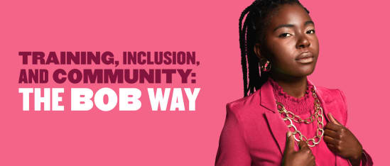 training inclusion community bob way, confident woman in pink blazer with statement jewelry against pink background