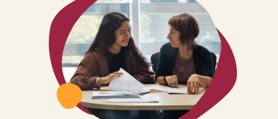 young woman and older woman discussing over documents at a table, engaged in collaborative conversation, two women interacting with papers in a bright setting