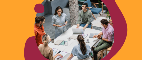 collaborative team meeting around a table with laptops, discussing ideas in a modern office space, diverse group brainstorming with digital devices
