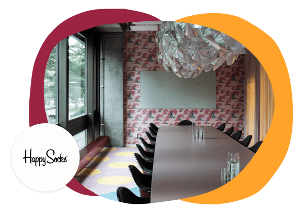 meeting room interior with colorful wave wallpaper and modern chandelier, Happy Socks branding visible on wall decoration