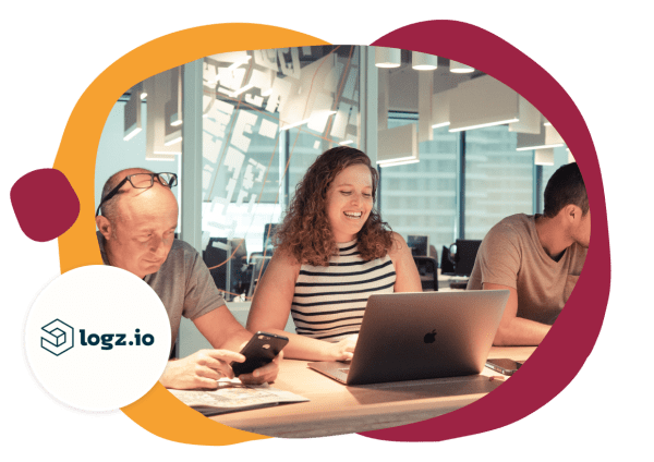 collaborative workspace with three individuals focused on devices; bright modern office interiors, logz.io logo, professional teamwork in a vibrant office setting, diverse individuals engaged in technology discussions