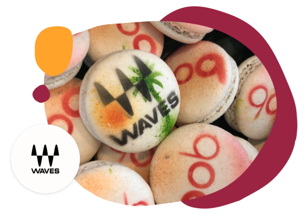 macarons with the 'WAVES' logo and colorful designs, featuring orange and green accents, creative dessert branding and presentation