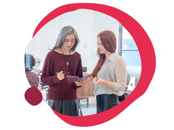 young women collaborating in a modern office, discussing ideas using a tablet, creative workspace atmosphere, collaboration and innovation in design studio setting
