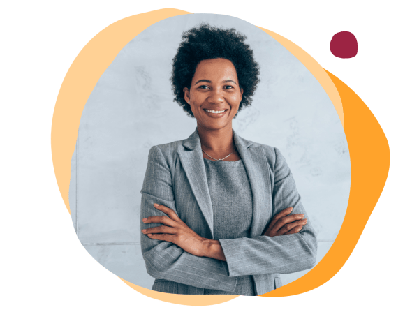 business professional, smiling woman in gray suit with arms crossed against a light backdrop