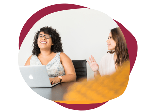 happy-women-laughing-office, women-discussing-laptop-table