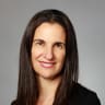 portrait of a woman with long straight hair, wearing a black top, smiling against a gray background, female professional headshot