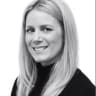 smiling woman with long blonde hair in a black turtleneck, plain white background, professional portrait, blonde woman smiling in monochrome photo