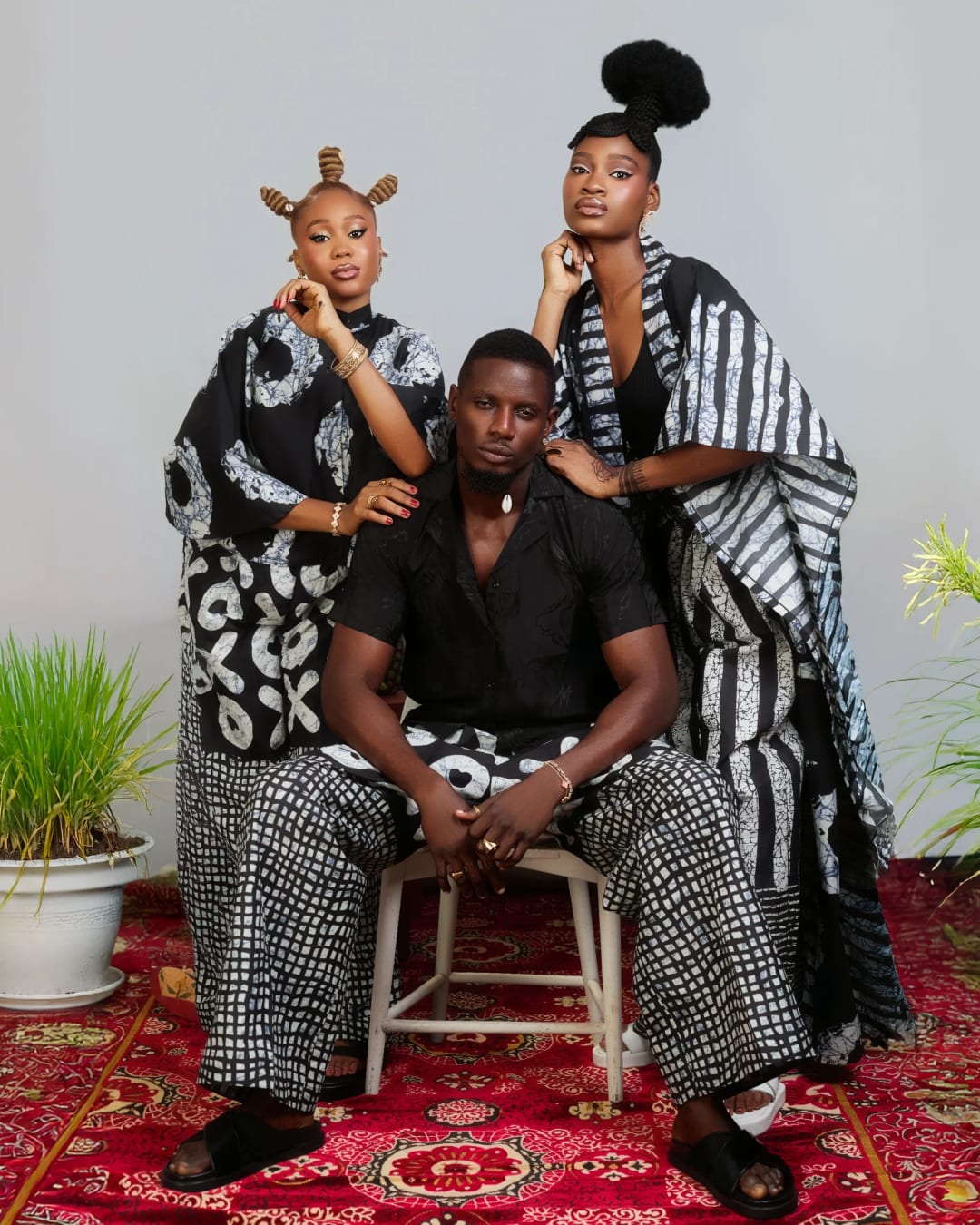 The Soft Ivory family in the red room, in adire and aso oke