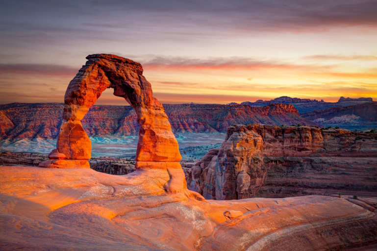 Sunset over the Delicate Arch rock formation in Arches National Park, Utah.
