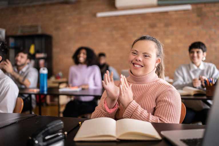 Young woman with special needs clapping in the classroom