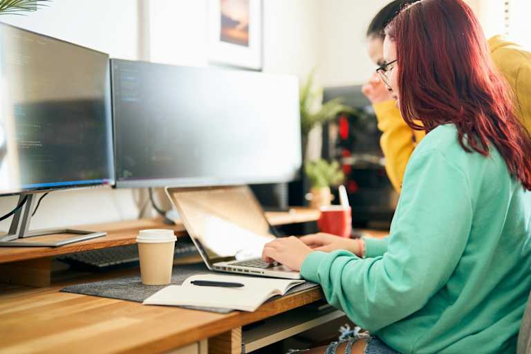 Two people coding on a computer together