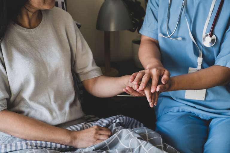 Nurse holding patient's hand