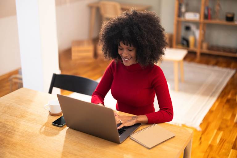 Woman typing on laptop at home