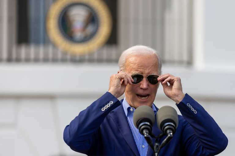 President Biden adjusting his sunglasses