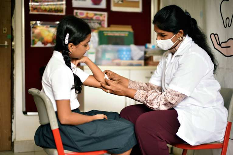 School nurse putting bandage on student's arm