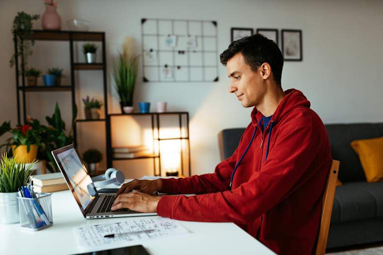 College student working on laptop at home