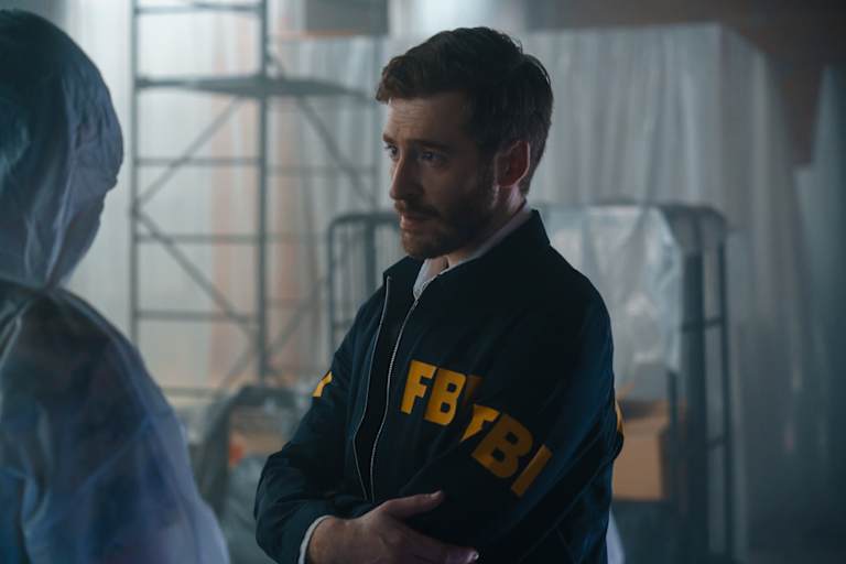 FBI agent and criminologist discussing with each other at a crime scene in an abandoned warehouse.