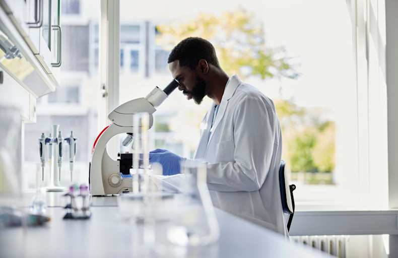 Scientist looking into microscope
